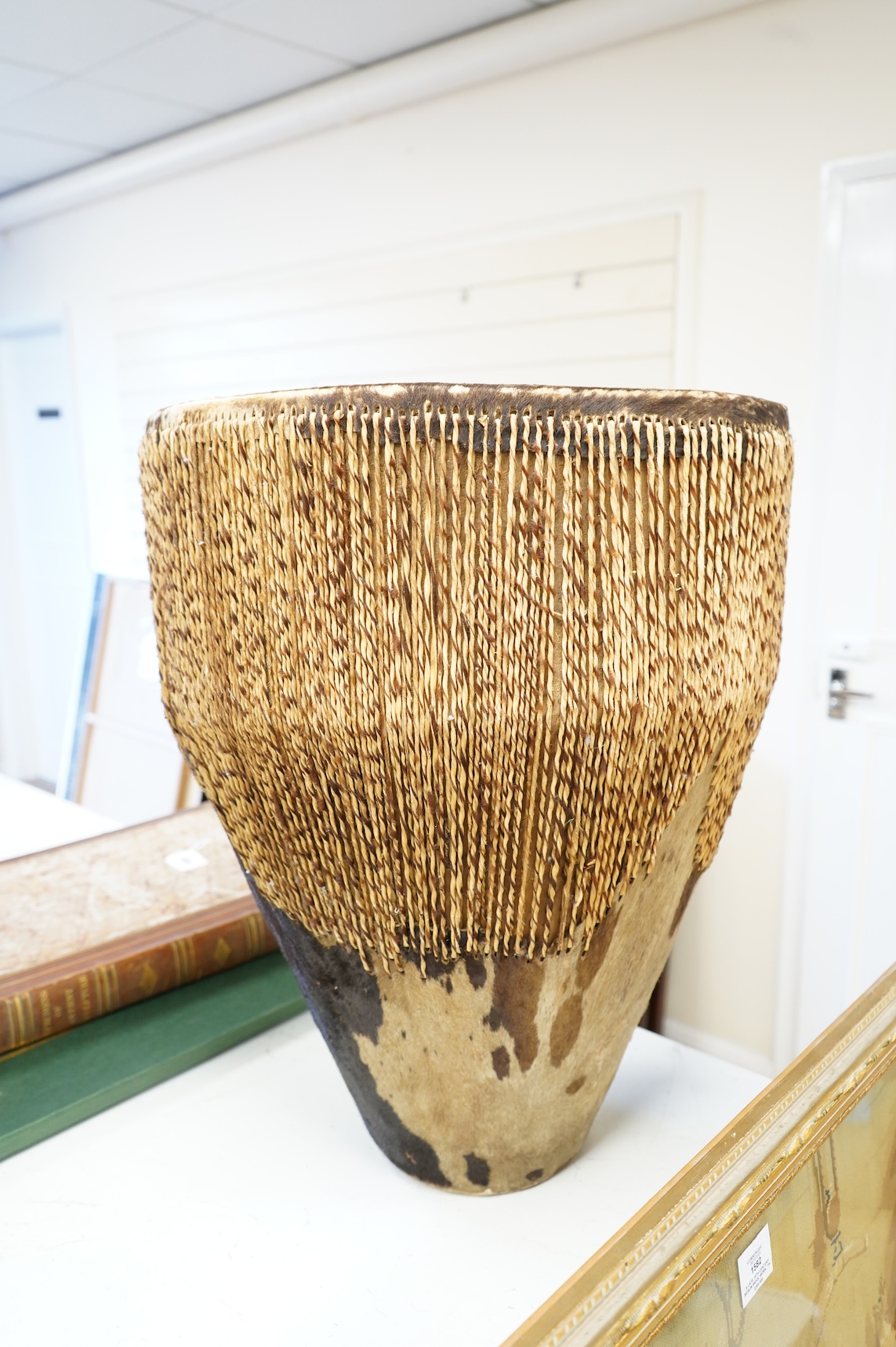 An African drum with a hide skin and gut stretchers, the body of the drum also covered with hide, diameter of the drum 46cm, the height 60cm